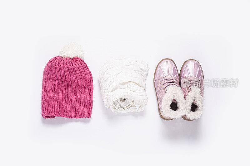粉色帽子，围巾，白色背景下的女孩穿的靴子。俯视图，平躺。