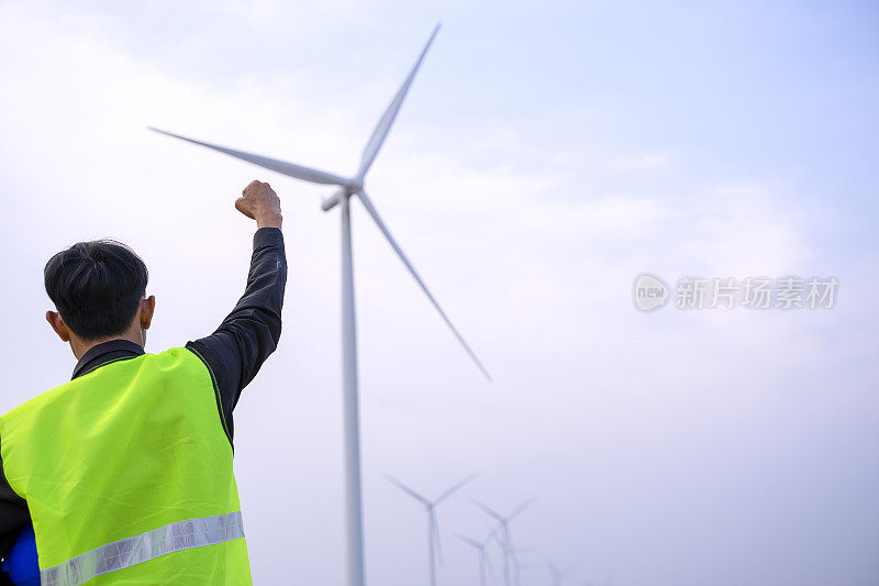 电力工地的蓝领工人。风车。