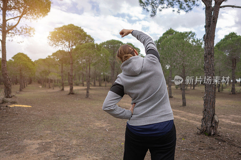 成熟的女性跑步者在晨跑前热身