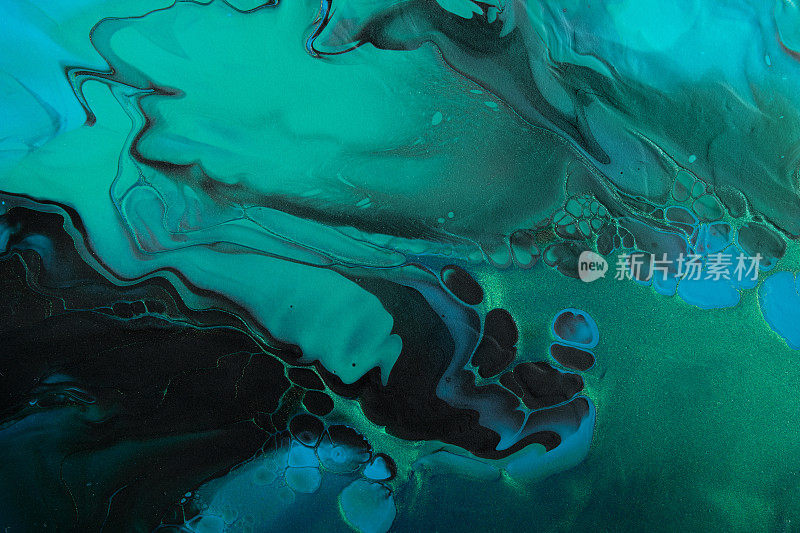 流体艺术。金属绿色和蓝色抽象波浪与黑色背景上的金色粒子。大理石效果的背景或纹理