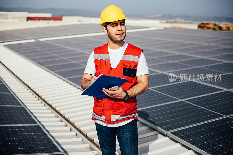 在电站工作的年轻工程师的太阳能电池板库存照片