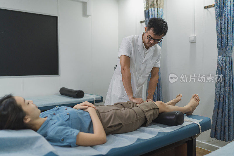 中医疗法——一位中医正在用按摩疗法治疗一位走路的女性病人