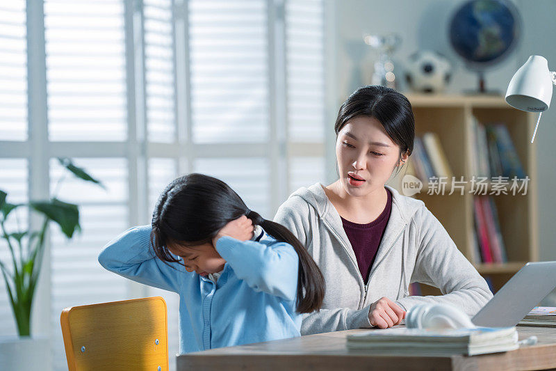 年轻妈妈和做作业的女儿生气