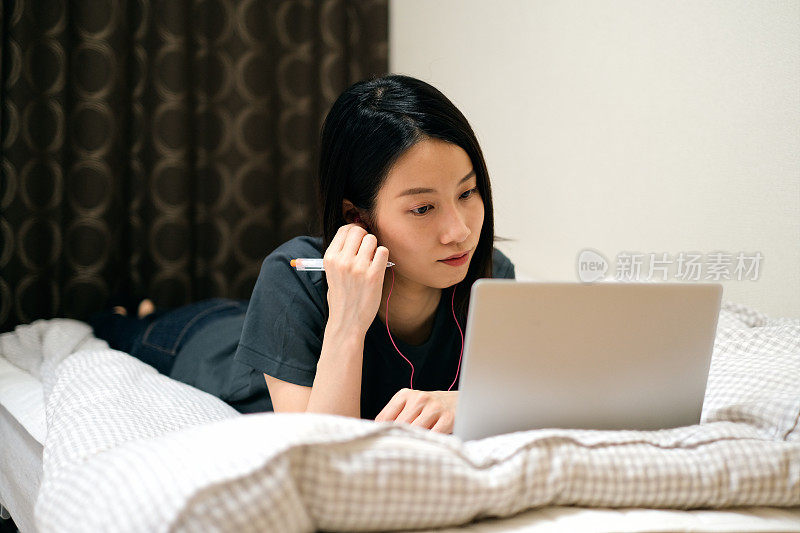 一个女人在床上在线学习的特写