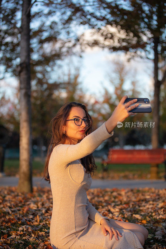 美丽的年轻女子戴着眼镜在大自然中自拍。