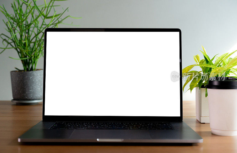 在家庭办公室的桌子上关闭空白白屏幕显示笔记本电脑作为在线零售商或视频电话给其他人或网站模板设计概念