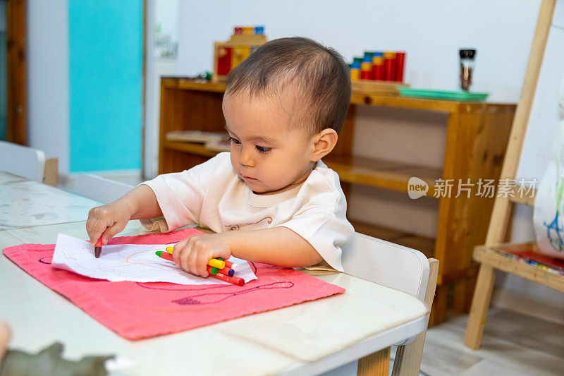 幼儿用油笔在纸上写字