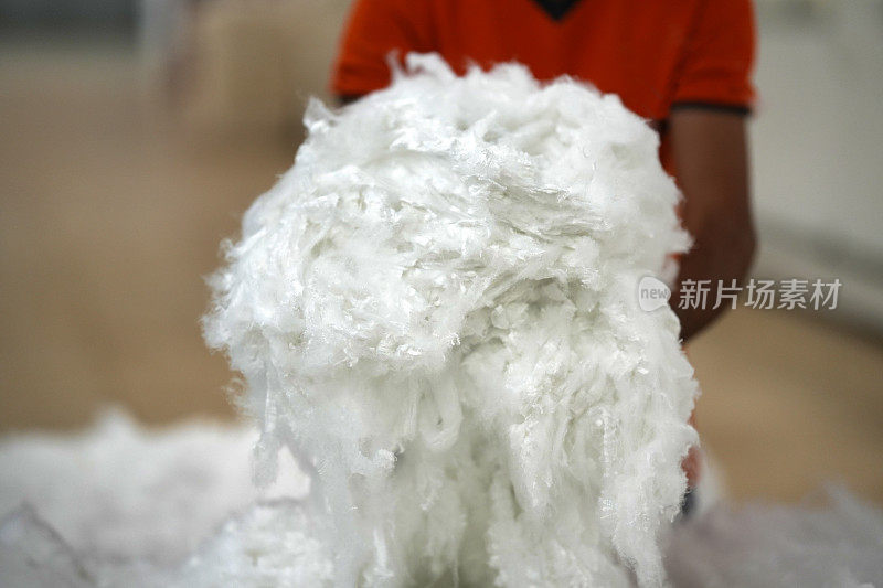 纺织厂工人手持有机回收棉上衣