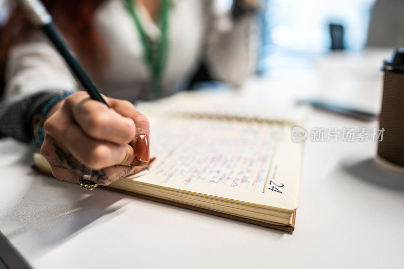 一个女人在办公室用记事本做笔记的特写