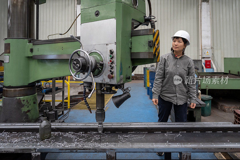 一位亚洲女工在一家机械厂工作