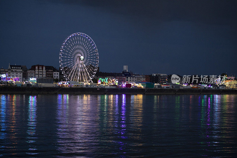 夜河上，灯火通明的大车轮和露天广场