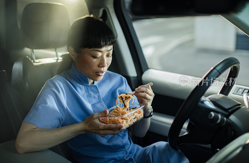 年轻的日本医护人员在车里吃午饭