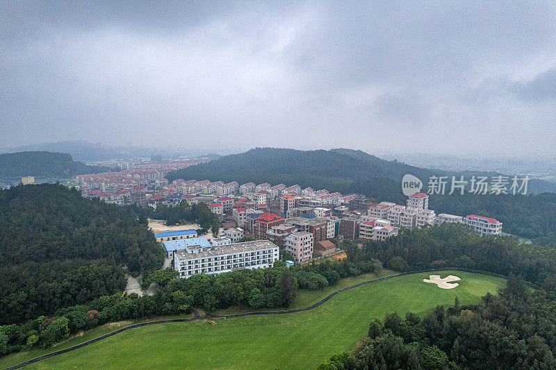 雾天高尔夫球场建筑和草坪的鸟瞰图