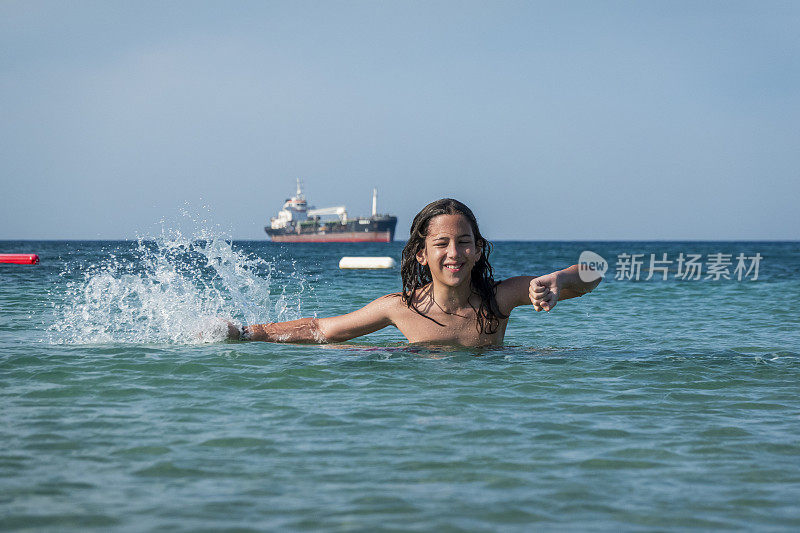 他用手在海里泼水。一个夏天的早晨。忒涅多斯岛。爱琴海北部，12岁的帅哥。长头发的