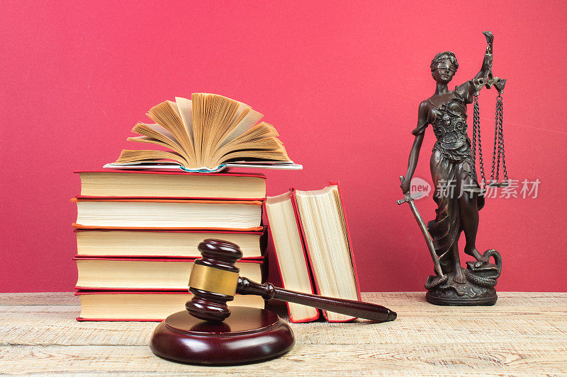 法律概念-打开法律书，法官的小木槌，天平，法庭或执法办公室桌子上的忒弥斯雕像。