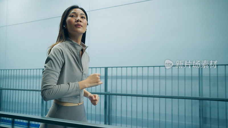 亚洲健硕年轻女子夜间在天空跑道慢跑和跑步，女性夜间运动，健康生活方式与运动活动，夜间户外健身