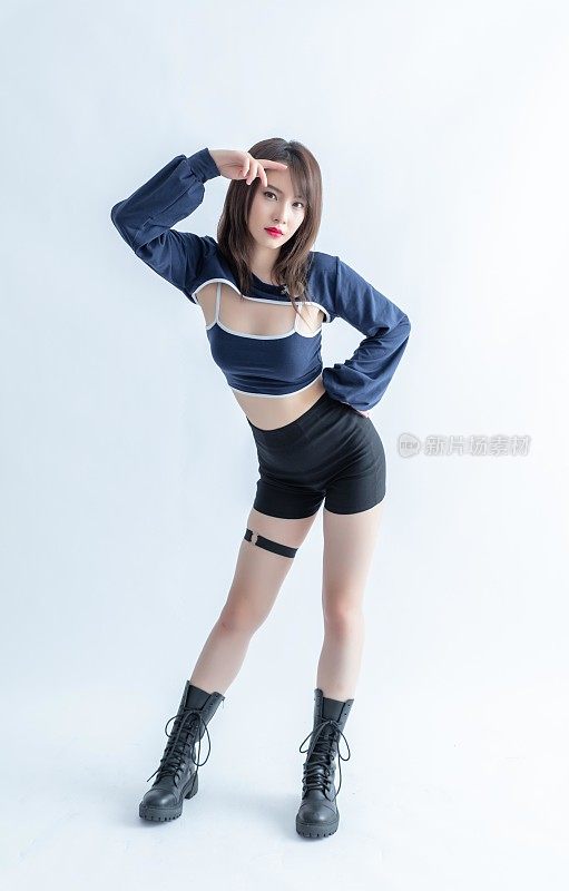 亚洲女人穿着暴露的衣服和战斗靴摆姿势