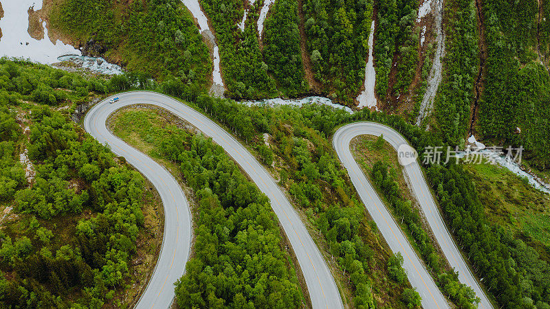 鸟瞰图汽车驾驶发夹路在风景秀丽的绿山山谷在挪威