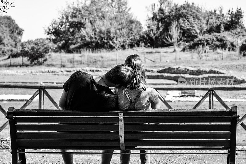水平横幅或标题，背面是一对年轻的z世代夫妇坐在校园公园的长凳上-黑白编辑