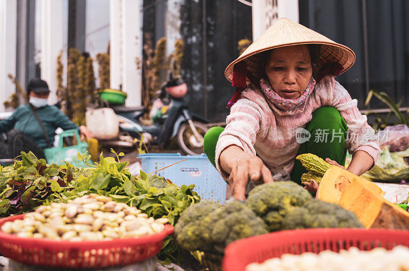 越南胡志明街市上卖蔬菜的妇女