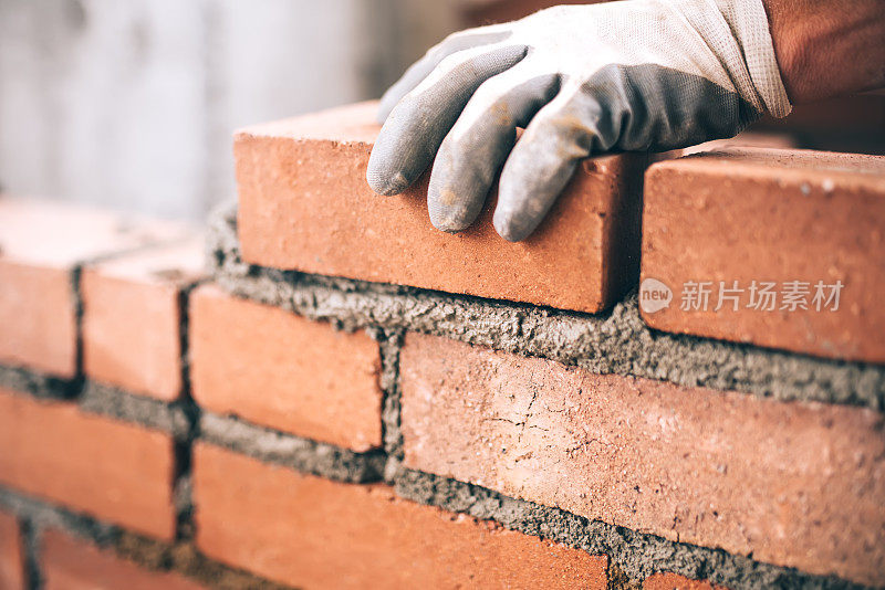 工业砌砖工人在建筑工地安装砖的特写