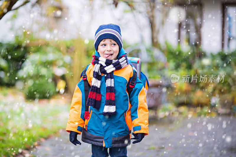 快乐的孩子男孩在冬天上学的路上