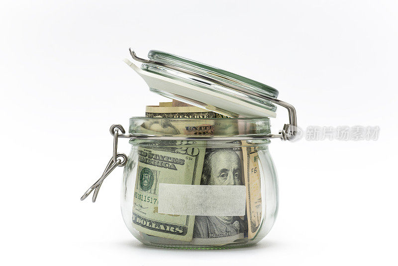在白色背景上孤立的玻璃罐中的美元。存钱的概念。