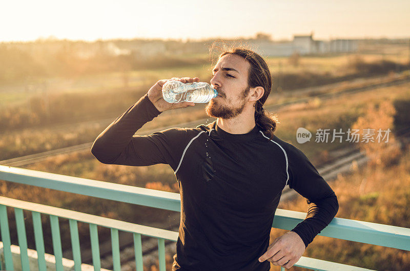 口渴的运动员在运动后喝水。