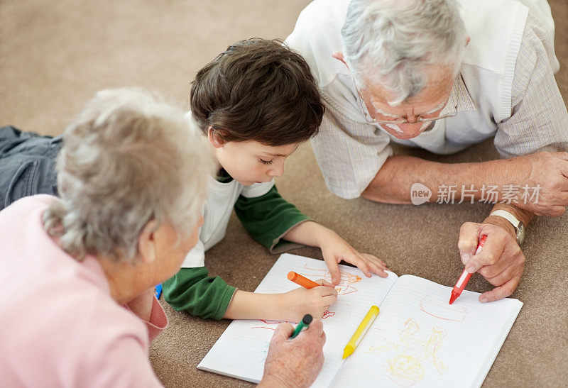 一对老夫妇在帮助他们的孙子画画