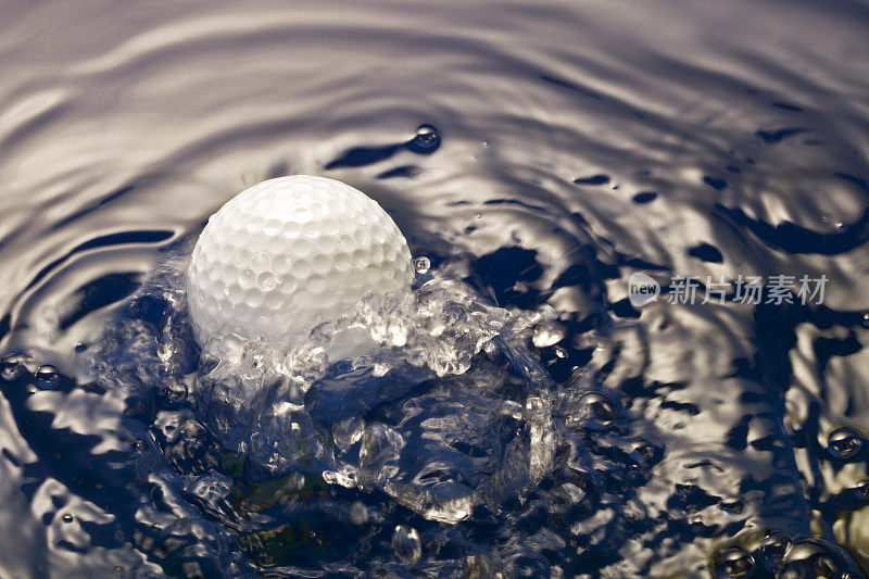 特写高尔夫球降落在水里，溅起水花