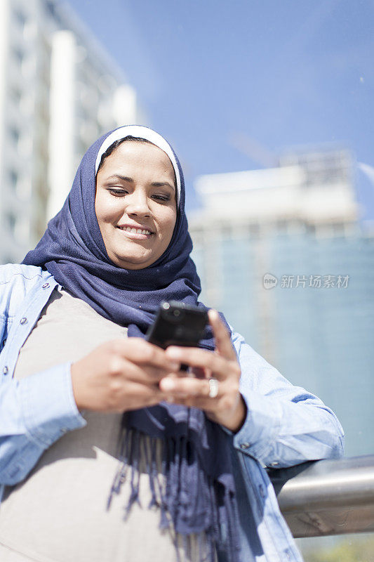 在开普敦，穆斯林妇女对着手机微笑