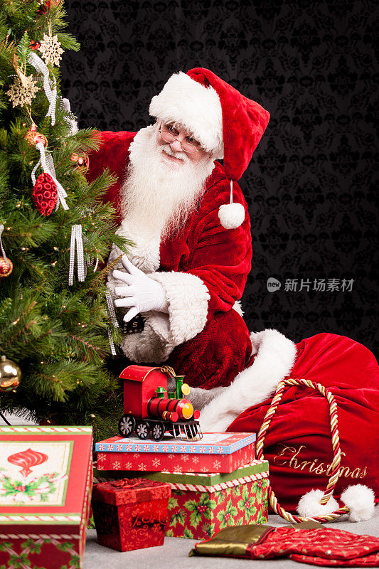 真正的圣诞老人把礼物放在树周围