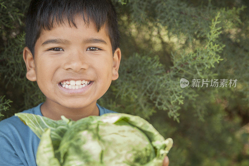 孩子们自豪地从社区菜园里收获蔬菜。