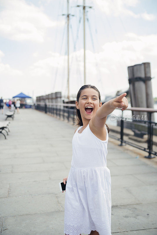 表情丰富的小女孩在纽约玩手机增强现实游戏。