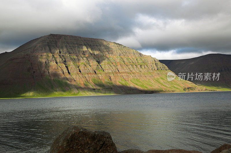 日出时山上乌云密布。Flateyri。Westfjords。冰岛。