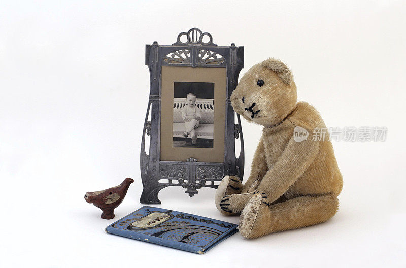 古董坐马海毛泰迪熊与年轻男孩的照片。