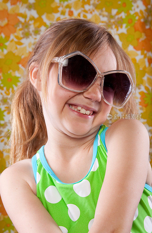 穿着泳衣的傻乎乎的小女孩，戴着太阳眼镜，复古的壁纸背景