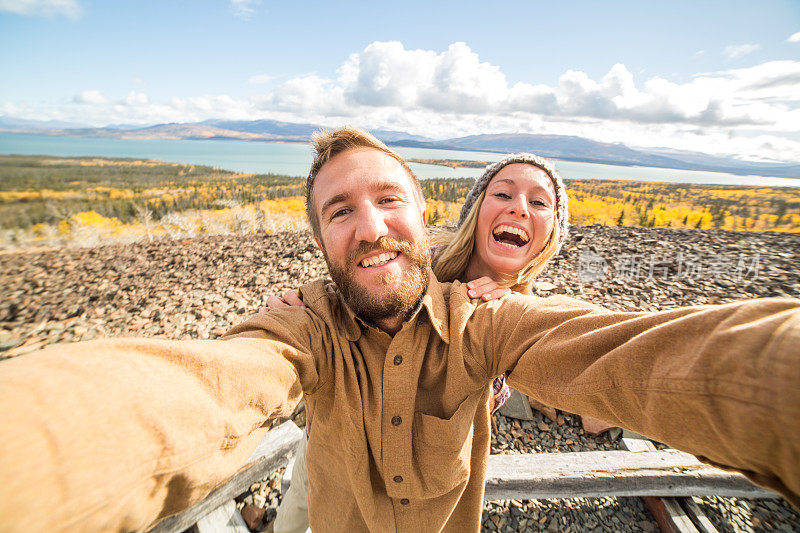 一对快乐的年轻夫妇在加拿大旅行时拍自拍照