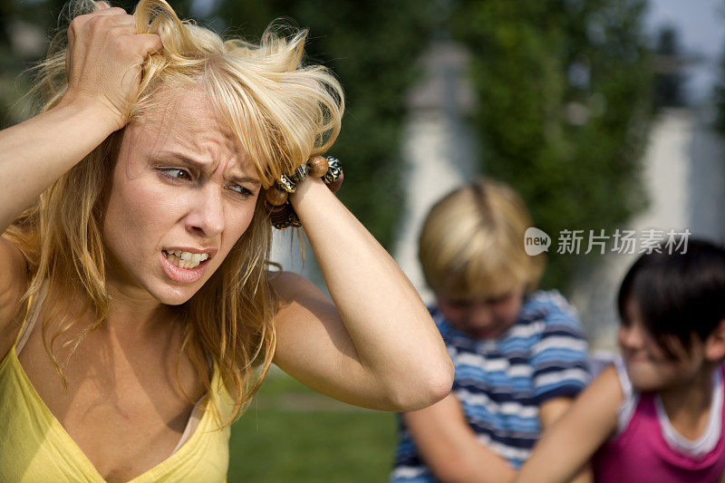 当孩子们打架时，女人沮丧地抓着头发