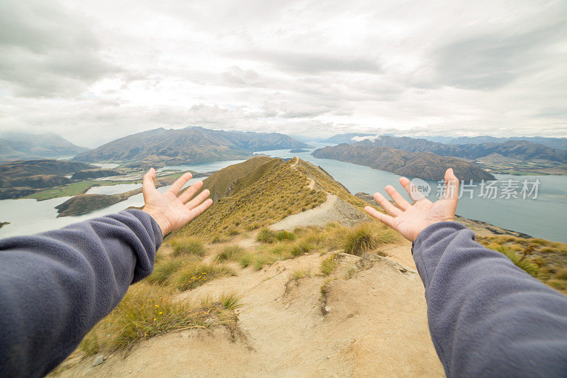 女性的手臂伸向山和湖景观