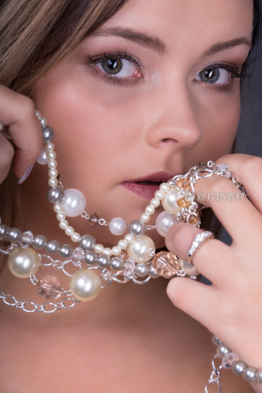 垂直特写的年轻女子与珍珠首饰。