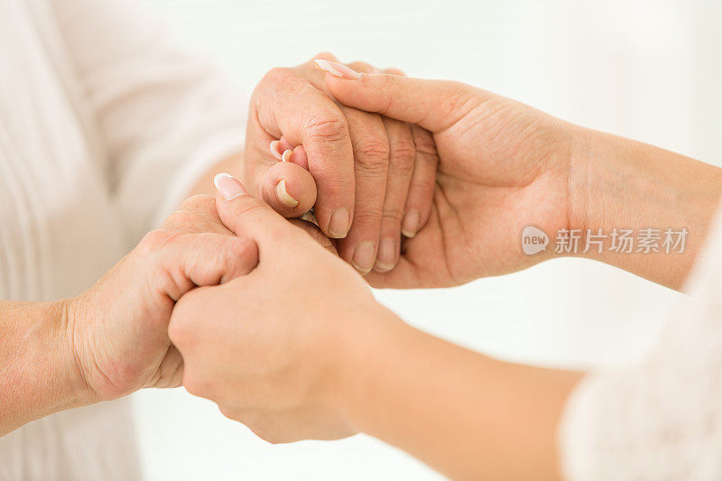 年长的和年轻的女人手牵着手