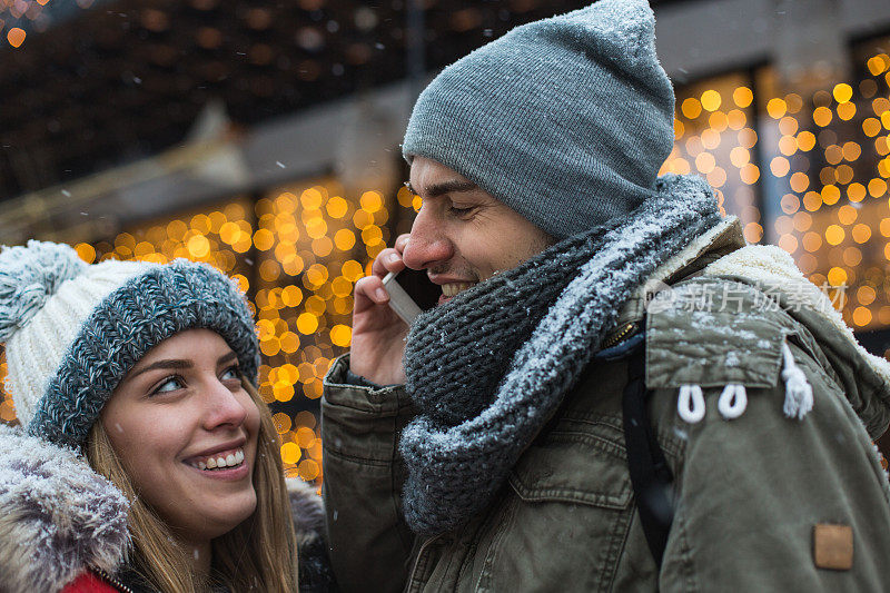 年轻夫妇在城市街道上使用手机