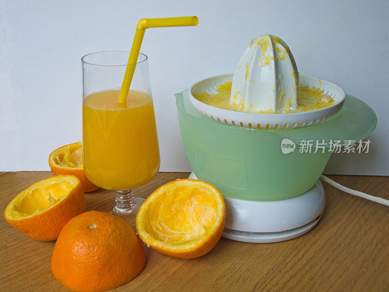 橙汁在玻璃杯中，饮用吸管和榨汁机
