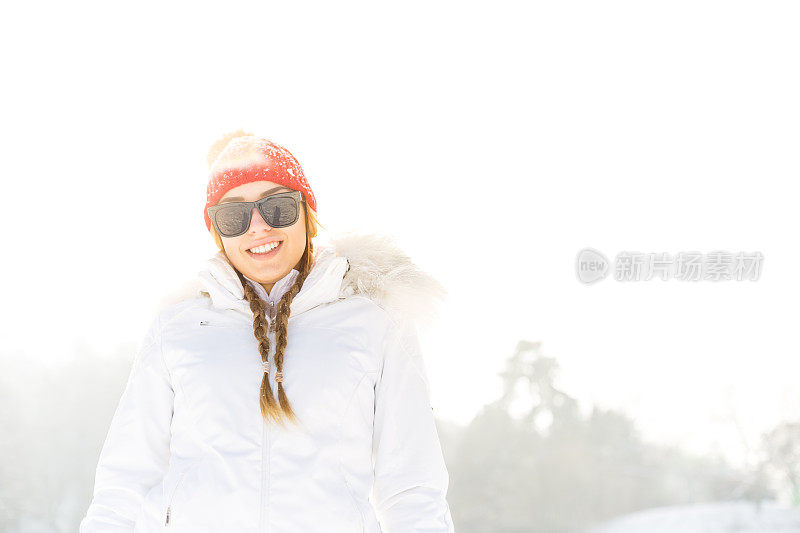 在雪地里戴着太阳镜和帽子的女人