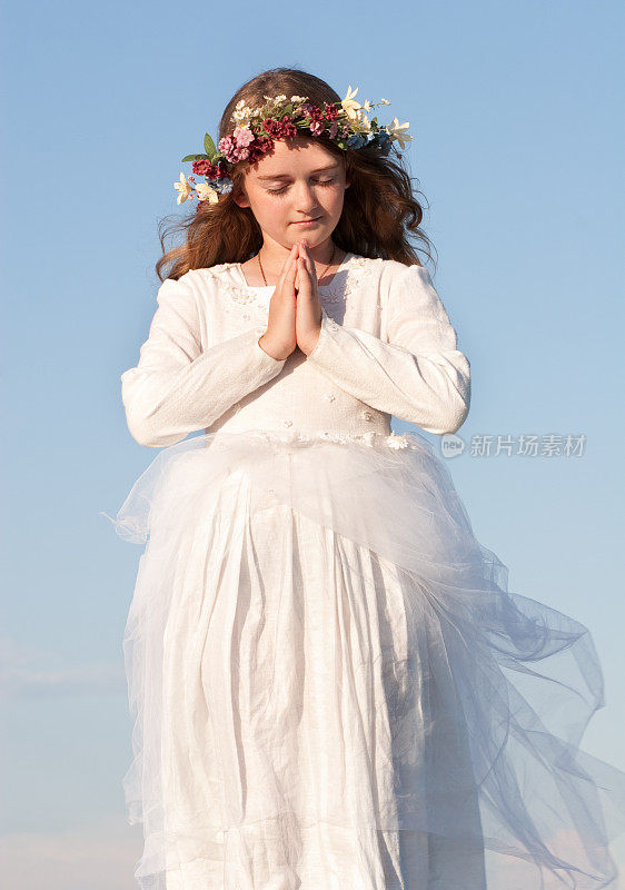 穿着白衣和花祈祷的小天使