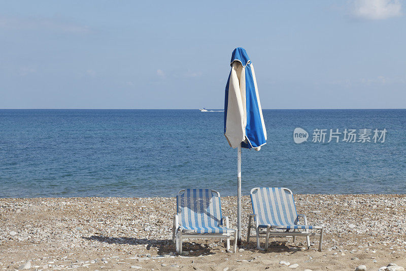 一把蓝白伞和条纹日光浴床，塞浦路斯Latsi海滩