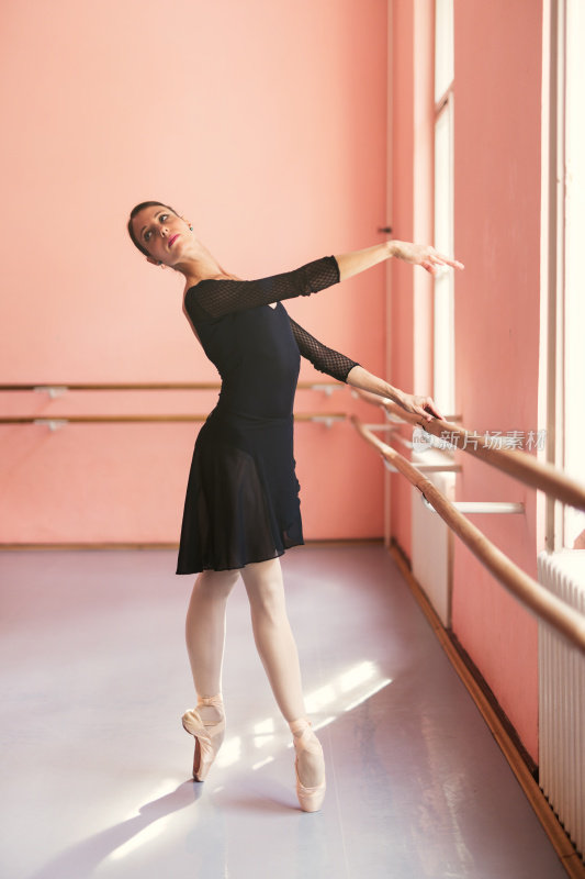 芭蕾舞女演员踮着脚尖靠近一根杆子。