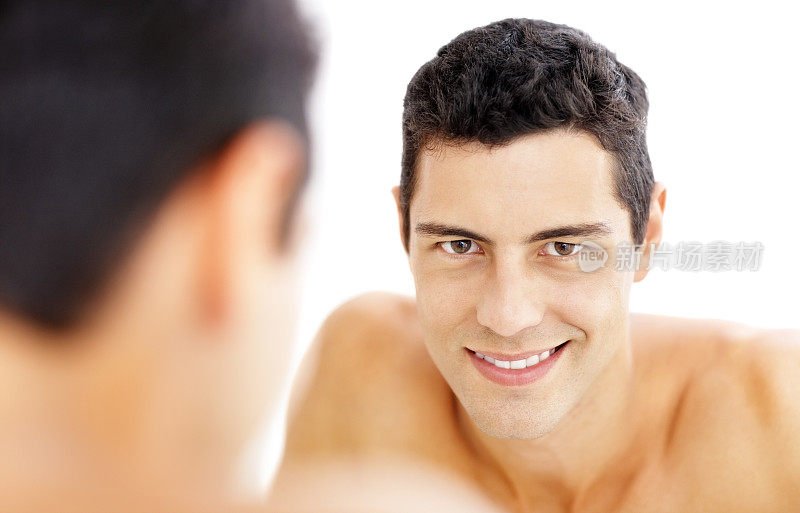 浴室镜子里的男人刮胡子后的微笑