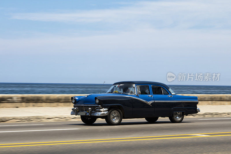古巴哈瓦那，一辆蓝色老式美国车在马勒孔高速行驶